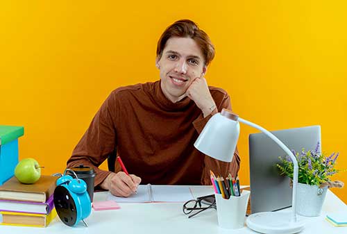Étudiant de l'école MJM Graphic Design posant avec des projets de direction artistique, illustrant les opportunités de poursuite d'études.